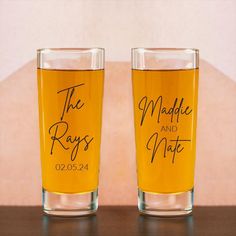 two shot glasses with the names and date printed on them sitting next to each other