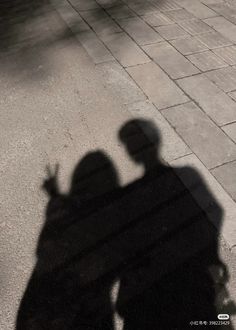 the shadow of two people standing next to each other