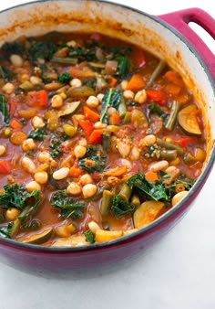 a red pot filled with stew and vegetables