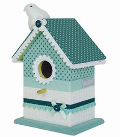 a blue birdhouse with white polka dots on it's roof and green trimmings