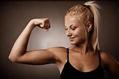 a woman flexing her muscles and looking at the camera