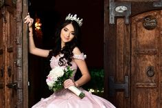 a beautiful young lady in a pink dress holding a bouquet and wearing a tiara