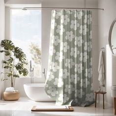 a bathroom with a bathtub, shower curtain and potted plant