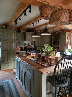 a kitchen with an island and two chairs in it, along with hanging lights above the counter