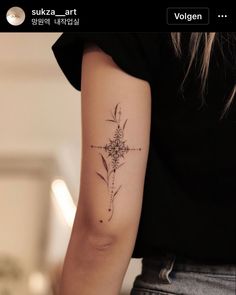 a woman's arm with a cross tattoo on the left side of her arm