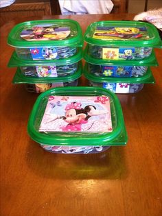 four plastic trays with mickey mouse designs on them sitting on a wooden table in front of a child's play set