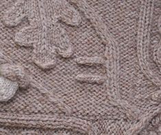 a close up of a knitted sweater with flowers on it