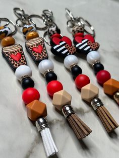 several key chains with tassels and charms attached to them on a marble surface