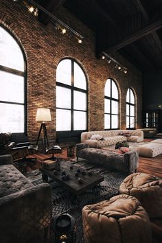 a large living room filled with lots of windows next to couches and tables in front of them