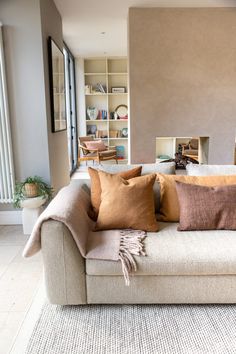 a living room filled with furniture and lots of pillows