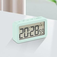 an alarm clock sitting on top of a white table