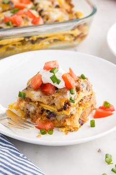 a slice of mexican casserole on a plate with a fork