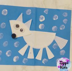 a paper cut out of a bird on a blue and white background with circles around it