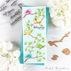 a card with birds and flowers next to some rubber stamps on a white table top