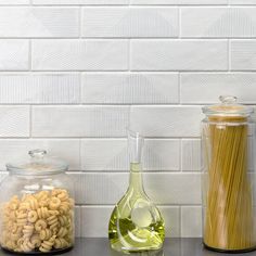 there are three different types of items on the shelf in front of the white brick wall