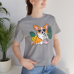 Introducing our Summer Corgi Unisex Graphic Tee – a must-have addition to your warm-weather wardrobe that combines adorable corgi charm with the laid-back vibes of summer! This tee isn't just clothing; it's a fun and stylish way to celebrate your love for these delightful pups and the sunny season. Crafted for both men and women who adore corgis, this tee is perfect for adding a touch of whimsy to your summer look, whether you're lounging at the beach or soaking up the sun by the pool. Featuring a playful corgi graphic and made from high-quality materials for comfort and durability, this tee is sure to become a favorite in your collection. Whether you're a proud corgi lover or searching for the perfect gift for a fellow dog enthusiast, our Summer Corgi Unisex Graphic Tee is guaranteed to b Summer Short Sleeve T-shirt With Dog Print, Summer Dog Print Relaxed Fit T-shirt, Summer Relaxed Fit T-shirt With Dog Print, Trendy Crew Neck T-shirt With Dog Print, Summer Dog Print Short Sleeve Top, Dog Print Crew Neck Graphic Tee, Short Sleeve Dog Print Top For Summer, Casual Crew Neck Tops With Dog Print, Summer Dog Print Graphic Tee