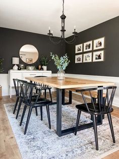 a dining room table with four chairs and a rug on the floor in front of it