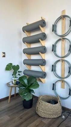 a wall mounted yoga mat rack in the corner of a room next to a potted plant