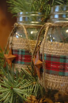 two mason jars decorated with plaid ribbon and wooden stars