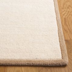 a close up of a white rug on a wooden floor with light colored wood floors