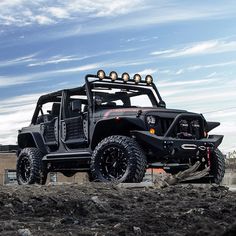 a black jeep is parked in the dirt