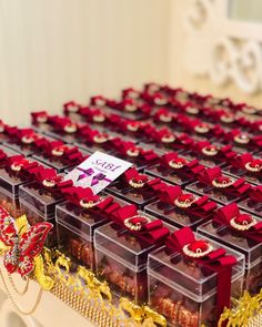 a table topped with lots of boxes filled with red and gold decorations on top of it