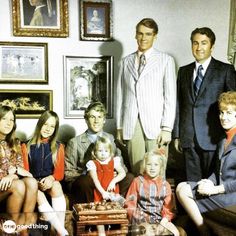 a group of people sitting next to each other in front of pictures on the wall