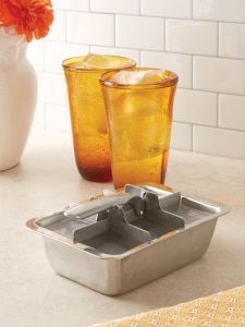 there are two glasses with ice in them on the counter next to an orange flower