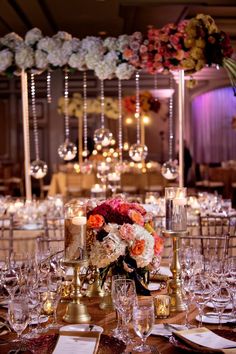 the table is set with candles, flowers and other decorations for an elegant wedding reception