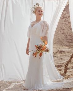 a woman in a white dress standing on the beach