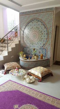 a living room filled with lots of furniture next to a stair case covered in tiles