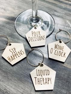 four wine charms sitting on top of a wooden table