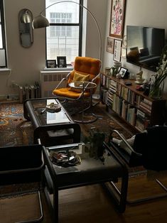 a living room filled with furniture and a flat screen tv mounted to the wall next to a window