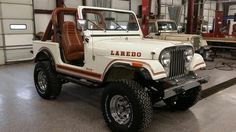 an old jeep is parked in a garage