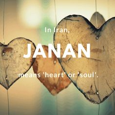 two wooden hearts hanging from strings with the words janan written in white above them