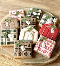 decorated christmas cookies on a plate with bows and presents tied to the top, sitting on a wooden table