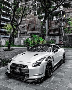 a white sports car parked in front of a building