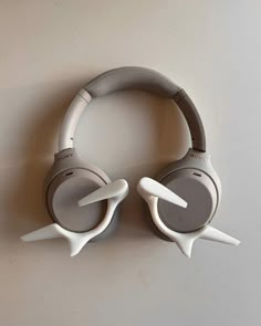 two white headphones are sitting on the wall next to each other and one is upside down