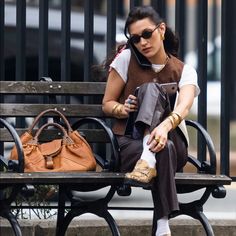 a woman sitting on a bench with a purse