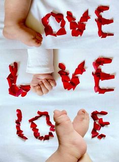 two hands holding the word love spelled with red tissue paper