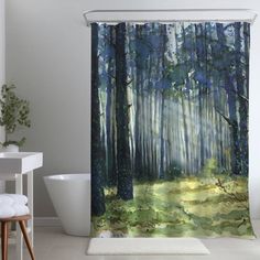 a bathroom with a shower curtain that has an image of trees in the woods on it