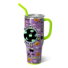 a purple and green cup with glows in the dark on it, featuring witches