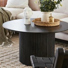 a living room with a couch, coffee table and plant on top of the table