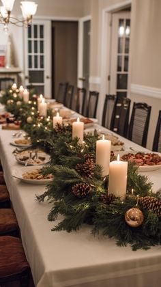 a long table is set with candles and pine cones for an elegant christmas centerpiece