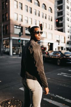 a man standing on the sidewalk in front of a traffic light