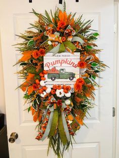 a wreath on the front door decorated with pumpkins