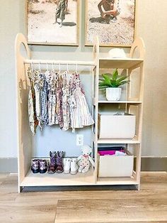 a baby's closet with clothes and shoes hanging on the wall next to it