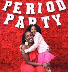 two women hugging each other in front of a red wall with the words period party on it