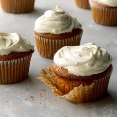 cupcakes with white frosting sitting on a table