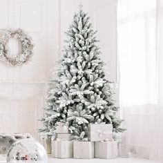 a white christmas tree with presents under it